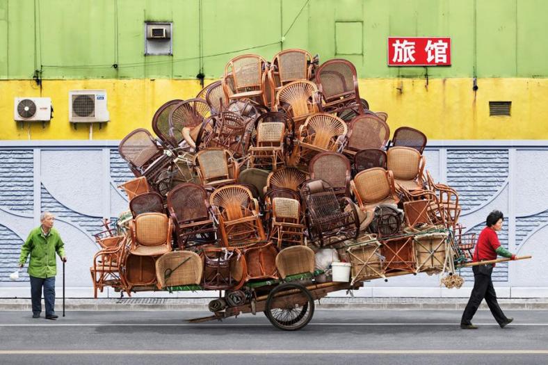 In his series 'Totems' set in Shanghai, China french photographer Alain Delorme pays homage to the underdog heroes of the city, migrant bicycle workers lugging around heaps of cargo to keep the ever-expanding city afloat. Delorme turns this real injustice into a surreal circus whereby he digitally alters his photos to better convey his message about the wealth disparity in China.  Hereby the migrants' loads have been digitally retouched and purposefully exaggerated to draw attention to the symbolism within Delorme's work. In addition, the photographer uses candy-coated hues to veer away from reality.