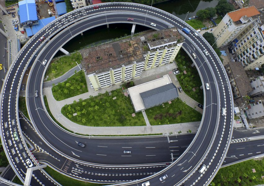 An old residential building is seen surrounded by a newly-built ring viaduct, in Guangzhou